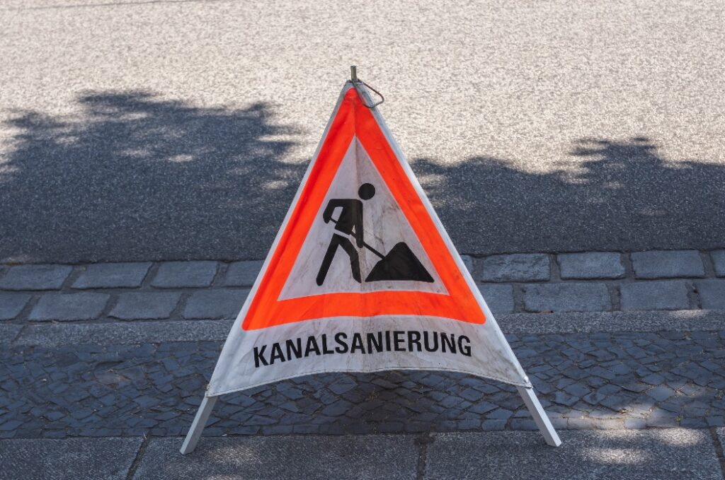 ein dreieckiges Warnschild für eine Kanalsanierung